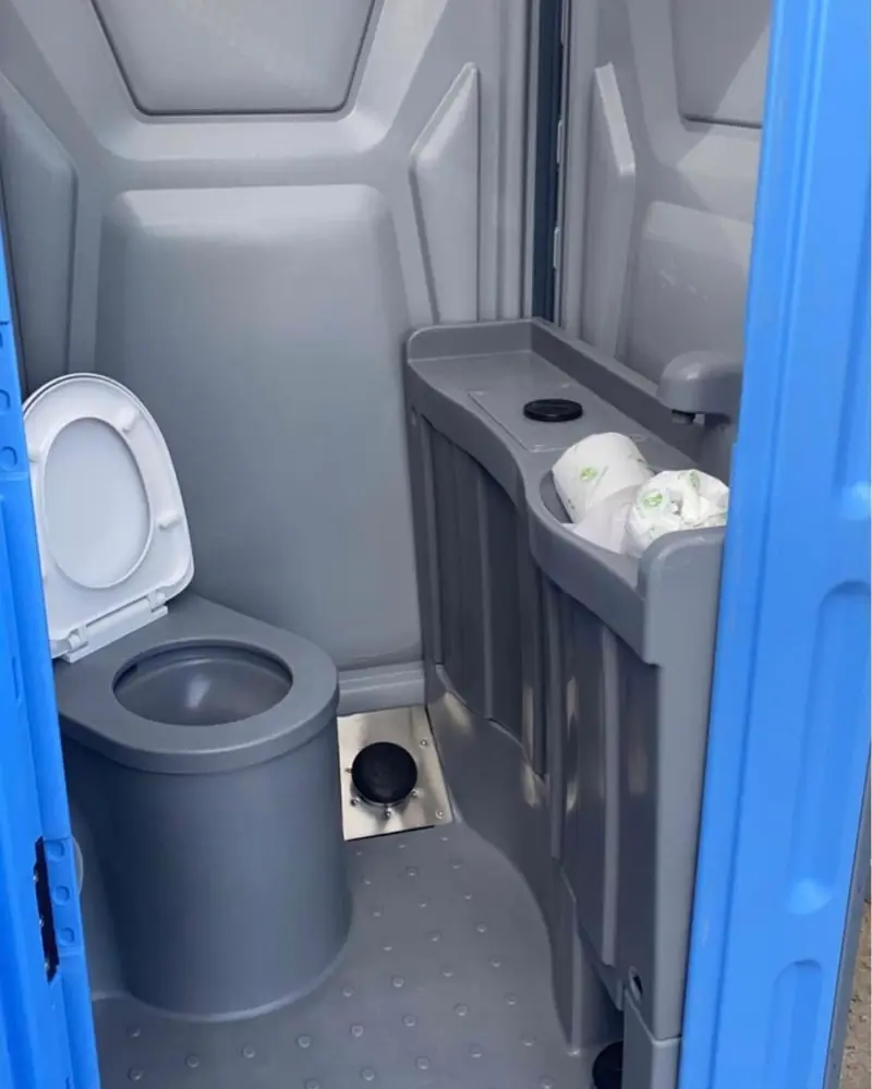 Inside a deluxe porta potty with seat and sink