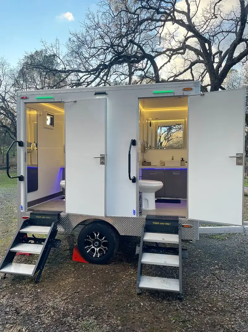 Restroom trailer lit at dusk for an event