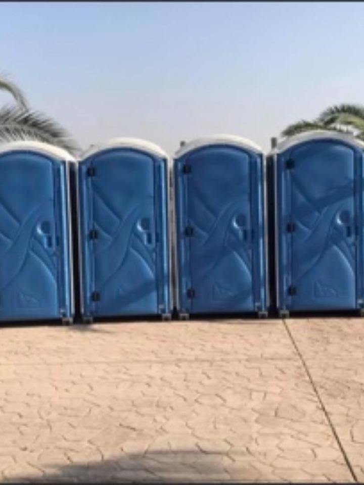 Row of blue porta potties at an outdoor event