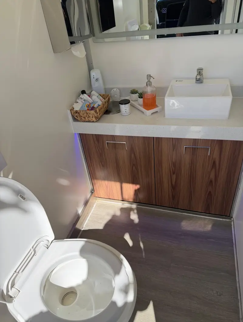 Wood vanity and sink inside a VIP restroom trailer
